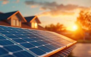 A close-up shot of solar panels capturing sunlight during sunset with homes in the background. The warm glow highlights sustainable energy solutions, promoting eco-friendly living. photo