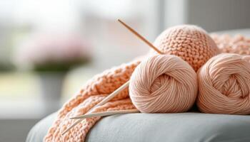 Knitting project in progress with soft peach yarn and wooden needles, creating cozy atmosphere. Perfect for crafting enthusiasts and home decor lovers photo