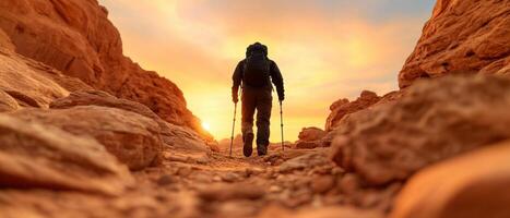 hiker traverses rocky canyon at sunset, surrounded by stunning rock formations. warm glow of sun creates serene atmosphere, perfect for adventure photo
