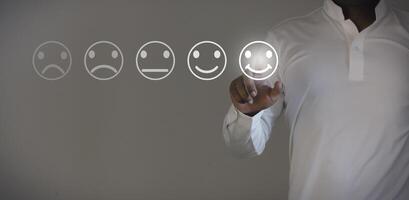 Business people are touching the virtual screen on the happy face icon to give satisfaction in service. Customer service and Satisfaction concept. photo