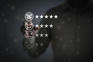 Business people are touching the virtual screen on the happy face icon to give satisfaction in service. Customer service and Satisfaction concept. photo