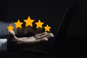 hand of customer or client holding the stars to complete five stars. with copy space. giving a five star rating. Service rating, satisfaction concept. photo