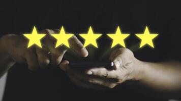 Close up man using smart phone and give five star symbol to increase rating of product and service concept, Customer service experience and business satisfaction survey. photo