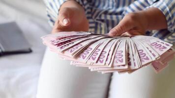 woman holds large stack of 200 Turkish lira bills in front of her, spreads it with a fan and shows it to the camera, a lot of money, but little value, high inflation in Turkey video