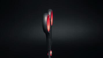 forbici con rosso maniglie su un' nero sfondo ruotare avvicinamento video