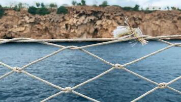 Calm Seascape View Through a Rope Net on a Cloudy Day at the Coastal Cliffside video