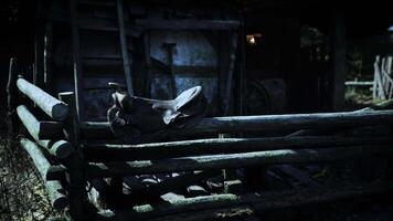 Old motorcycle resting on a rustic wooden fence near an abandoned barn at dusk video