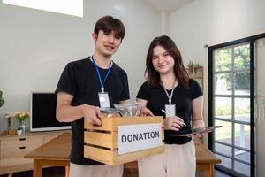 Smiling Volunteers Promoting Charitable Efforts with Donation Boxes photo