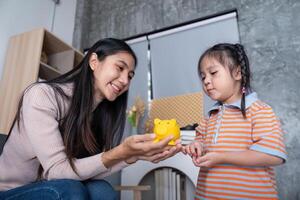 Mother Teaching Daughter Importance of Savings using Piggy Bank Interaction photo