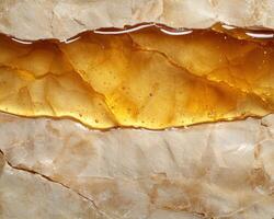 Detailed close up of golden amber honey dripping from a natural honeycomb photo