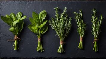 Fresh herbs and greens arranged on a slate board for culinary use. photo