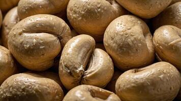 Close-up of light brown, glossy nuts with a smooth texture and droplets of moisture. photo