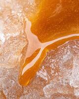 Close up of golden honey dripping from a honeycomb photo