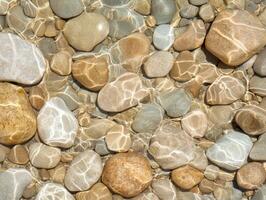Smooth river rocks in shallow water photo