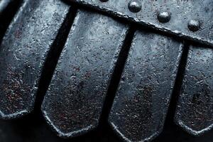 Closeup of a dark, textured metal surface with rivets photo