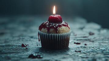 Delicious cupcake with lit candle on dark background photo