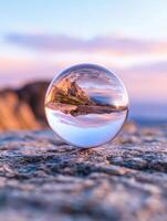Sunset reflected in a crystal ball on the beach photo