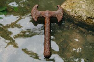 Rusty old metal tool in a pond photo