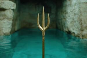 golden trident against a dark background photo