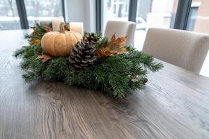 Cozy autumn decor with pumpkin and pine cone arrangement photo