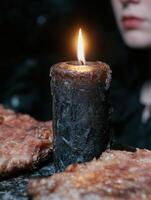 Flickering candle flame on dark background photo