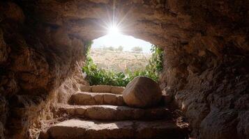 Sunlit cave entrance with stone steps and lush vegetation photo