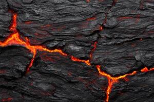 Glowing molten lava flowing through dark volcanic rock photo