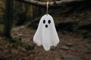 Spooky ghost hanging from tree branch photo