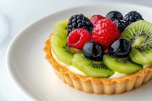 Colorful fruit tart with kiwi, raspberries, and blackberries photo
