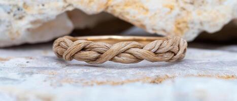 Braided rope bracelet on a rocky surface photo