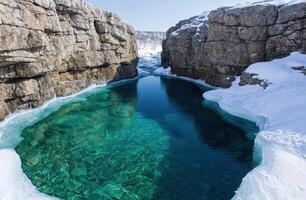 Breathtaking frozen lake surrounded by snow capped mountains photo