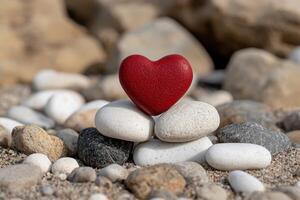 Red heart shaped object on pebbles photo