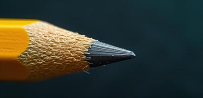 Close up of a sharp pencil tip on a dark background photo
