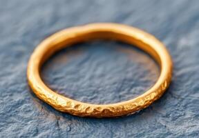 Textured gold ring on a dark background photo