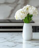 beautiful white hydrangea flowers in a vase on a marble table photo