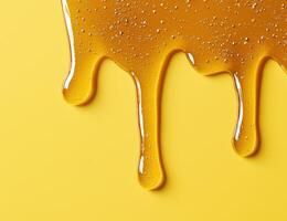 Dripping honey on yellow background photo