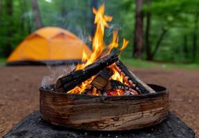 Campfire in the forest with a tent in the background photo