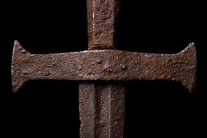 Rusty medieval sword on black background photo