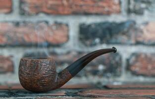 Vintage smoking pipe on rustic wooden table photo