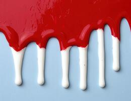 Dripping red paint on white background photo