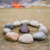 Zen stones in a field with a fire in the background photo