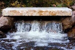 Cascading waterfall flowing over stone structure photo