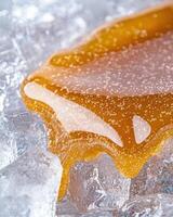 Delicious honey dripping over ice cubes photo