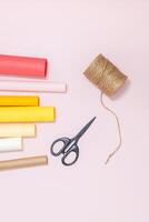Crafting tools on pastel background with colorful rolls of paper. photo