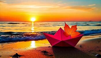 Paper boat at the autumn sunset beach. Romantic pink paper boat. Lovely autumn concept - paper boat with red leaf on coastline. photo