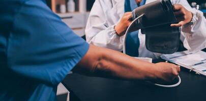 A doctor taking a patient's blood pressure. The patient's arm is equipped with a blood pressure cuff, and the doctor is using a blood pressure monitor. photo