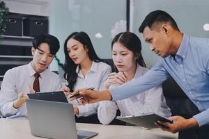 Entrepreneurs and business people conference in modern meeting room, happy multiracial coworkers have fun cooperating working together at office meeting, asian teamwork concept photo