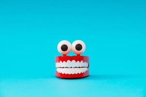 Plastic toy teeth on light blue background. Minimal abstract composition. photo