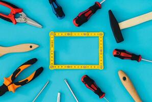 Pattern made of household tools with creative carpenter wooden folding ruler copy space on blue background. Minimal hand working tools concept. Trendy household tools idea. Flat lay. photo