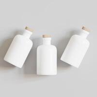 Three empty white bottles on a gray background photo